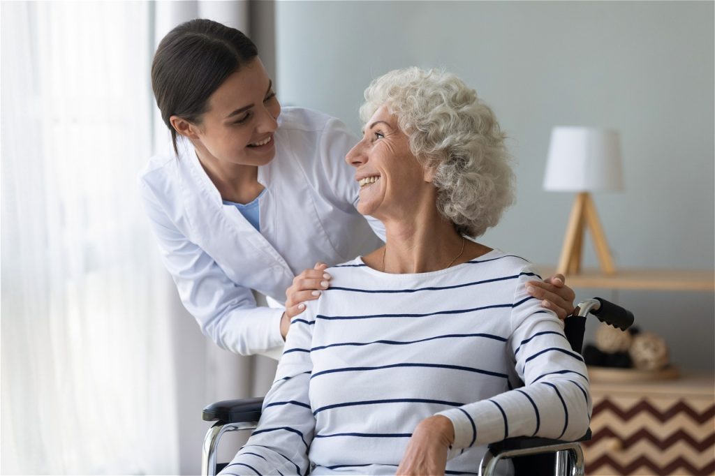 Pflegekraft spricht mit Seniorin